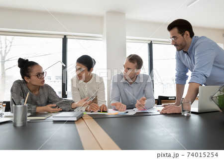 Multiethnic startup team gathering in office, discussing project 74015254