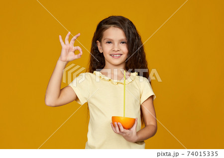 cute little child girl holding fresh juicy grapefruit 74015335