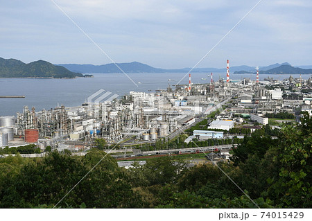 広島県大竹市小方の市道から見た、三菱ケミカルを中心とした工場とJR山陽線の電車 74015429