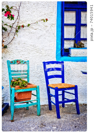 Typical cute wooden chairs in street taverna in Greece. artistic picture Typical cute wooden chairs in street taverna in Greece. artistic picture 74015941
