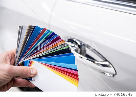 Man choosing color of his car with color sampler. 74016545