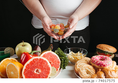 Overweight woman choosing unhealthy food Overweight woman choosing unhealthy food 74017575