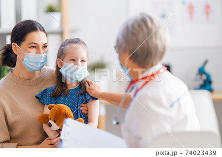 Doctor, child and mother wearing facemasks Doctor, child and mother wearing facemasks 74023439