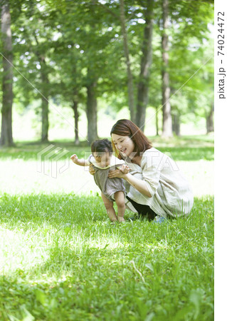 新緑の公園で遊ぶ家族 74024472