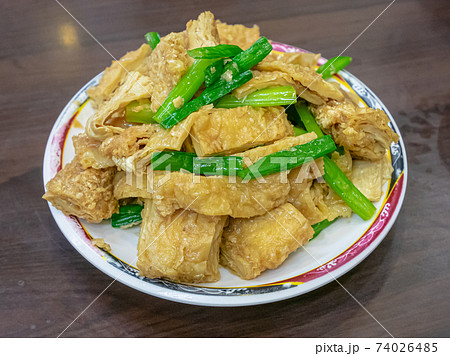 A close up of Taiwan traditional stir-fried tofu skin (bean curd sheet), Taiwanese food on wood table at restaurant in Taiwan night market. A close up of Taiwan traditional stir-fried tofu skin (bean curd sheet), Taiwanese food on wood table at restaurant in Taiwan night market. 74026485