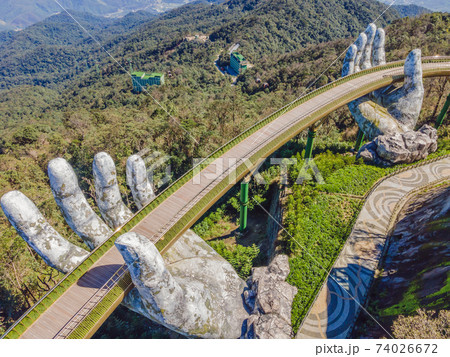 Famous tourist attraction - Golden bridge at the top of the Ba Na Hills, Vietnam Famous tourist attraction - Golden bridge at the top of the Ba Na Hills, Vietnam 74026672