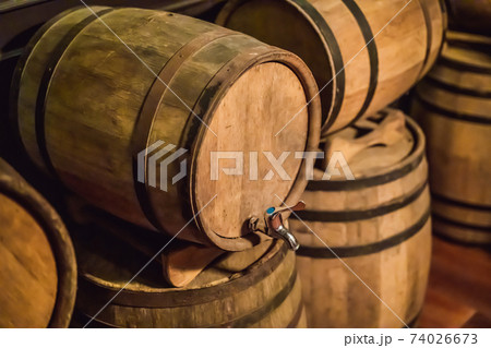 Wine barrels stacked in the old cellar of the winery 74026673