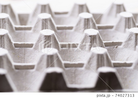 Cardboard box for raw eggs close-up. Gray egg carton. Recycling paper container for packing raw eggs. Packing material. Egg crate Cardboard box for raw eggs close-up. Gray egg carton. Recycling paper container for packing raw eggs. Packing material. Egg crate 74027313