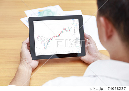 Business financial and technology concept rear view Businessman hands with tablet and candlestick symbols chart on screen. Businessman hands use tablet network control trade buy and sell stock market. Business financial and technology concept rear view Businessman hands with tablet and candlestick symbols chart on screen. Businessman hands use tablet network control trade buy and sell stock market. 74028227