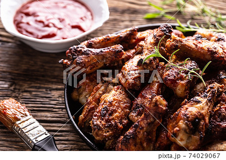 Chicken wings barbeque in a cast iron baking dish Chicken wings barbeque in a cast iron baking dish 74029067