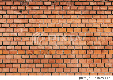 A wall of brown bricks. Close-up of brick wall texture. A wall of brown bricks. Close-up of brick wall texture. 74029447