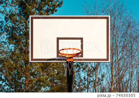 Basketball hoop in the park with autumn trees in background Basketball hoop in the park with autumn trees in background 74030305