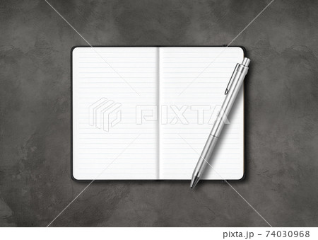 Black open lined notebook with a pen isolated on dark concrete background 74030968