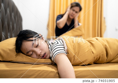 Asian teenage girl snoring loudly,open mouth,drooling on pillow,feeling tired exhausted,unhappy woman or mother covering ears with both hands,annoyed by the snoring of child girl,danger of sleep apnea Asian teenage girl snoring loudly,open mouth,drooling on pillow,feeling tired exhausted,unhappy woman or mother covering ears with both hands,annoyed by the snoring of child girl,danger of sleep apnea 74031905