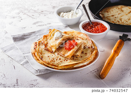 Stack of russian pancakes blini with red caviar, fresh sour cream 74032547