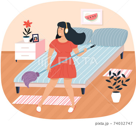 Musician sings and imagines guitar in bedroom. Girl with headphones washing floor and playing Musician sings and imagines guitar in bedroom. Girl with headphones washing floor and playing 74032747