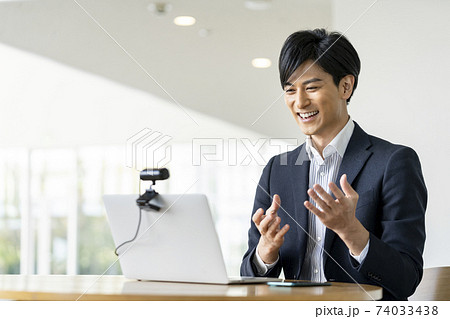 ウェブカメラに向かって話す若いビジネスマン　ビデオ通話　オンライン会議　イメージ 74033438