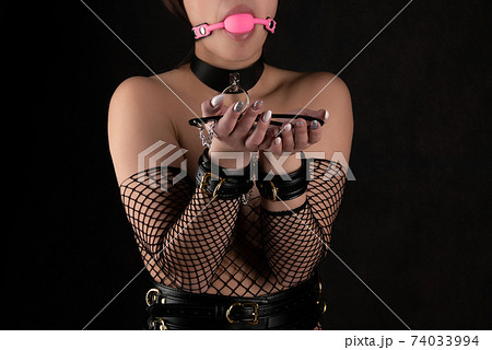 Beautiful woman in the role of a slave on a leash on black background Beautiful woman in the role of a slave on a leash on black background 74033994