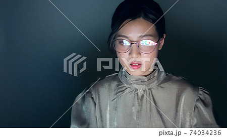 暗い部屋でpcを見る女性の写真素材