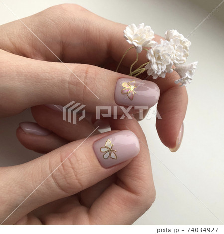 Stylish trendy female pink manicure.Pink manicure with butterfly design Stylish trendy female pink manicure.Pink manicure with butterfly design 74034927