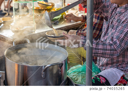 Vietnamese woman selling pig organs porridge at street food vendor 74035265