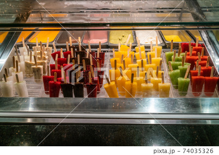 Colorful fruit ice pop and ice cream displayed in freezer Colorful fruit ice pop and ice cream displayed in freezer 74035326