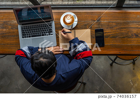 Young stock broker analyzing financial candlestick graph on laptop Young stock broker analyzing financial candlestick graph on laptop 74036157