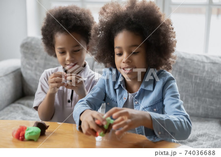 Close up little African American kids playing with colorful plasticine Close up little African American kids playing with colorful plasticine 74036688