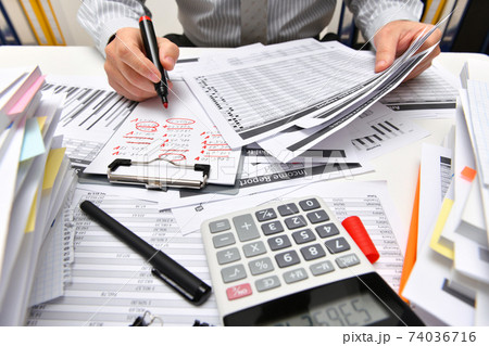 business concept - businessman working with reports in office, table and workspace close view, analyzing financial data, writes and counts business concept - businessman working with reports in office, table and workspace close view, analyzing financial data, writes and counts 74036716