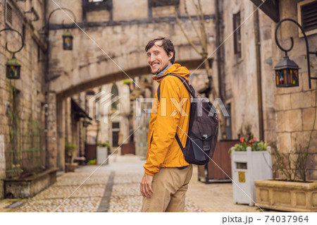 Young man tourist walks down the street in a European city after the end of COVID-19 coronavirus. quarantine is over 74037964