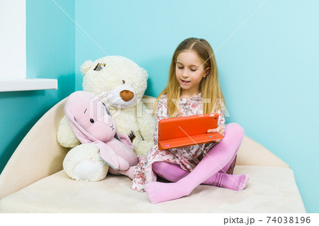 Schoolgirl watch tablet with toys at home Schoolgirl watch tablet with toys at home 74038196