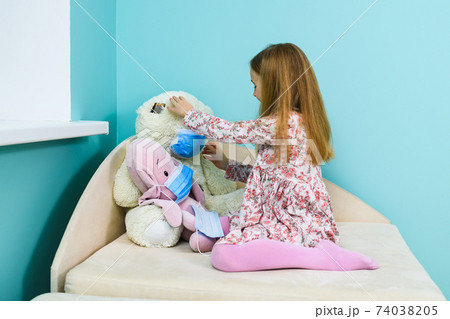 Small girl wear mask on teddy bear 74038205