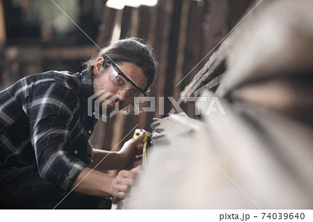 Carpenter, joiner is working in the workshop. Man at work on wood.Image of mature carpenter in the workshop,furniture making concept. 74039640