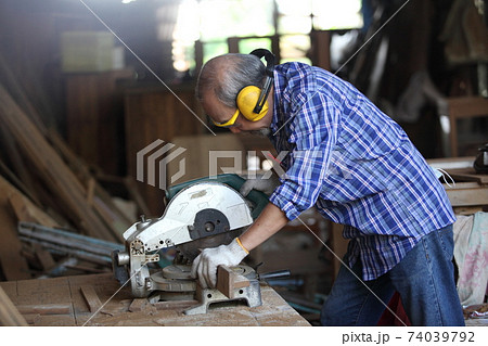 Carpenter, joiner is working in the workshop. Man at work on wood.Image of mature carpenter in the workshop,furniture making concept. 74039792