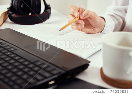 Remote work. Woman makes notes in notebook and using laptop for study. Distance education and e learning concept Remote work. Woman makes notes in notebook and using laptop for study. Distance education and e learning concept 74039835