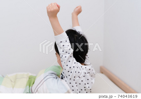 朝ベットから起きて背伸びする男の子 74043619