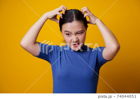 Asian woman scratching her head. Asian woman scratching her head. 74044051