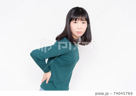白背景の前に立って、腰に手を当てている女性 白背景の前に立って、腰に手を当てている女性 74045769