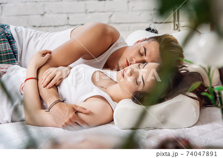 Young loving couple sleeping in pajamas in the bed Young loving couple sleeping in pajamas in the bed 74047891