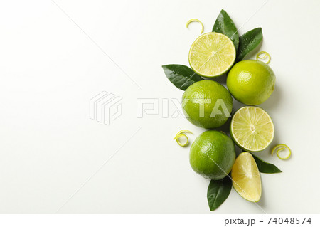 Ripe lime, leaves and peel on white background 74048574