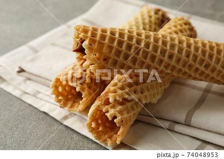 Napkin with wafer rolls with condensed milk on gray background Napkin with wafer rolls with condensed milk on gray background 74048953