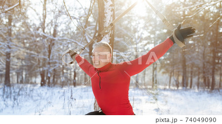 Total resistance fitness. Mature man working out with TRX system, training with suspension straps in snowy winter forest Total resistance fitness. Mature man working out with TRX system, training with suspension straps in snowy winter forest 74049090