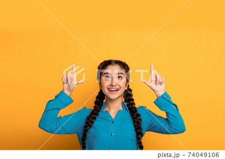 Excited indian woman pointing up at copy space 74049106