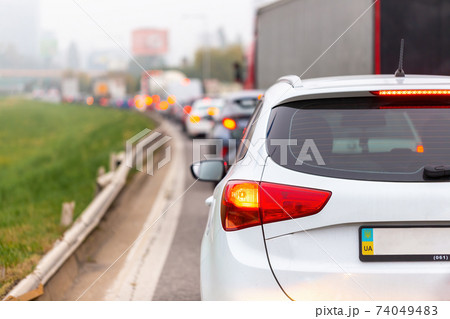 Cars waiting in traffic jam with illuminated brake lights 74049483