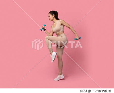Young Woman Exercising With Dumbbells Isolated On Pastel Background 74049616