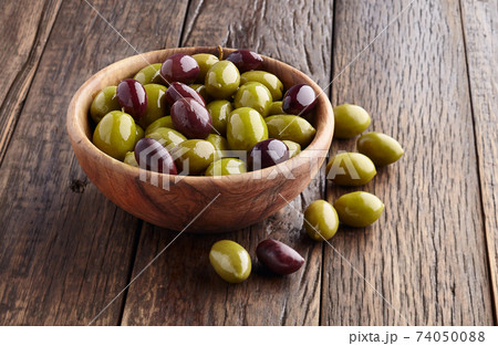 Green olives and kalamata olives on wooden background 74050088