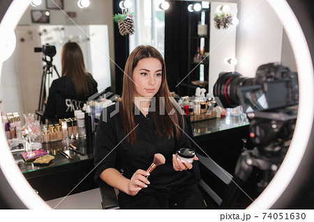 Young beautiful woman and professional beauty make up artist blogger recording makeup tutorial in beuty studio to share on website or social media. Woman use ring lamp and digital camera 74051630