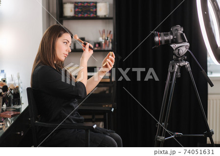 Young beautiful woman and professional beauty make up artist blogger recording makeup tutorial in beuty studio to share on website or social media. Woman use ring lamp and digital camera 74051631