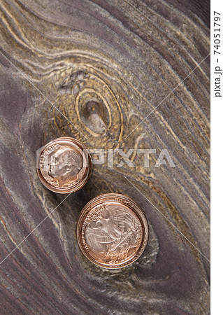 Two stacks of coins on wood. 74051797