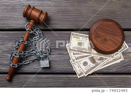 Top view chained gavel and dollars. 74052465